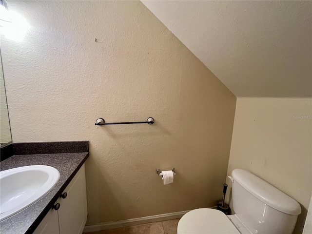 2254 Chianti Pl Unit 68, Palm Harbor, FL 34683 - bathroom featuring vanity, toilet, lofted ceiling, tile patterned flooring, and baseboards