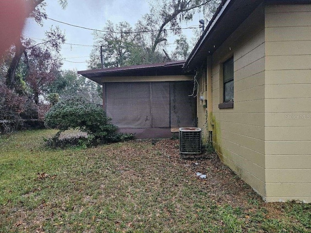 view of home's exterior with cooling unit and a lawn