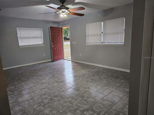 unfurnished room with ceiling fan and tile patterned flooring