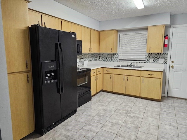 kitchen with sink, black appliances, a textured ceiling, light brown cabinetry, and decorative backsplash