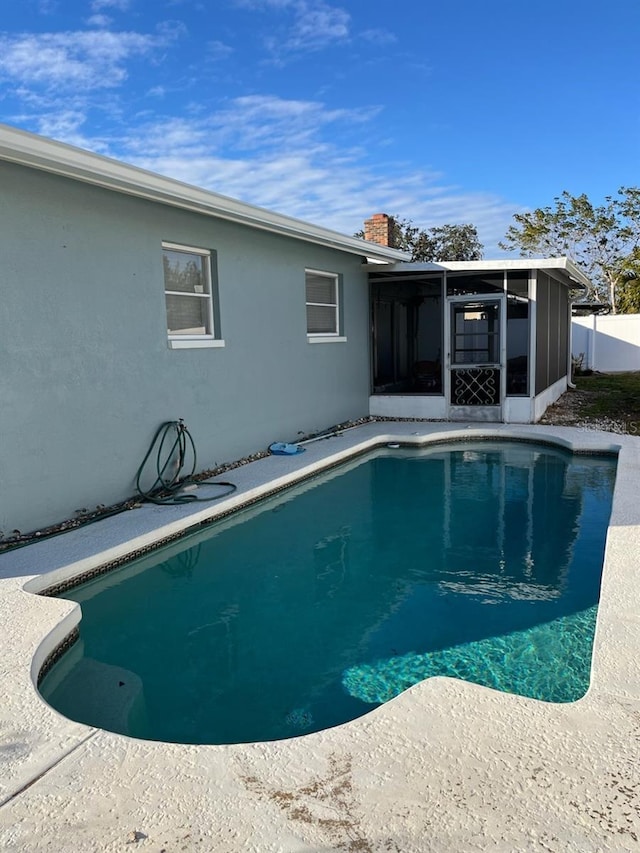 view of swimming pool with a sunroom