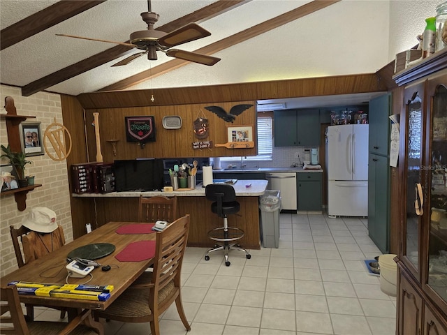 kitchen featuring dishwasher, vaulted ceiling with beams, brick wall, kitchen peninsula, and white fridge