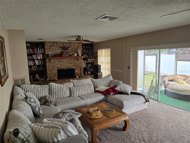 living room featuring carpet floors, ceiling fan, a fireplace, and a textured ceiling