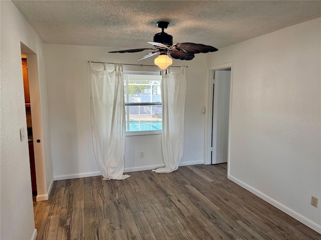 spare room with ceiling fan, dark wood-type flooring, and a textured ceiling