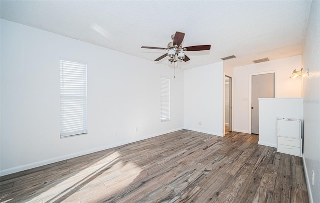 spare room featuring hardwood / wood-style flooring, ceiling fan, and a textured ceiling