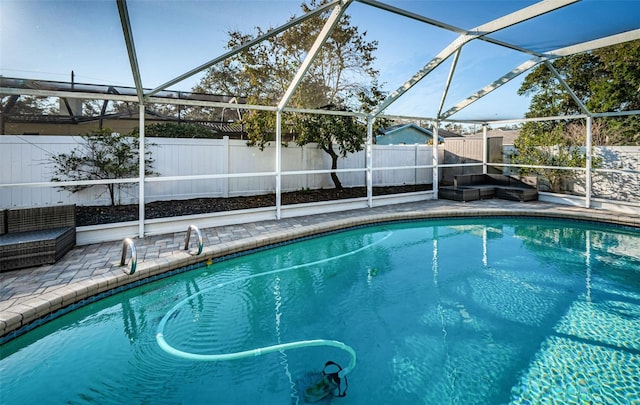 view of pool with glass enclosure and a patio area