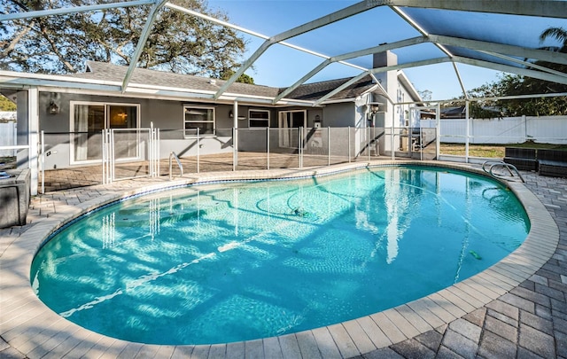 view of pool with glass enclosure and a patio area