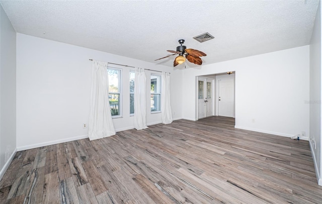 unfurnished room featuring ceiling fan, wood-type flooring, and a textured ceiling