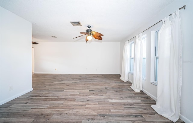 spare room with ceiling fan, wood-type flooring, and a textured ceiling