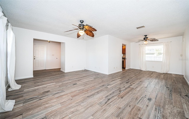 unfurnished living room with ceiling fan, light hardwood / wood-style flooring, and a textured ceiling