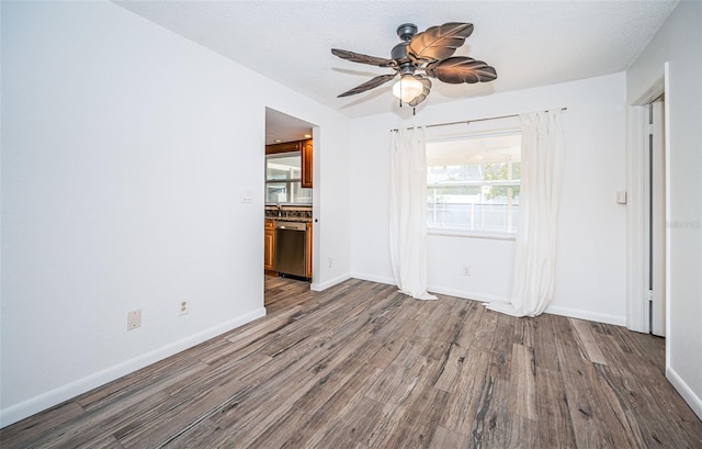 unfurnished room featuring ceiling fan, wood-type flooring, and a textured ceiling