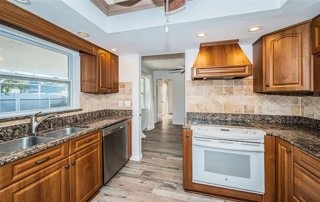 kitchen with white electric range, sink, stainless steel dishwasher, ceiling fan, and custom range hood