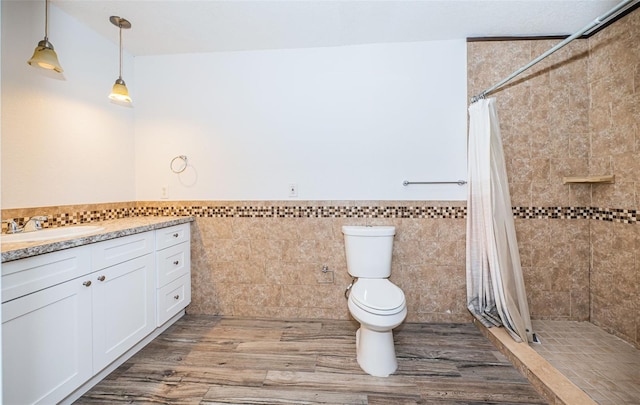 bathroom featuring toilet, tile walls, vanity, and a shower with curtain