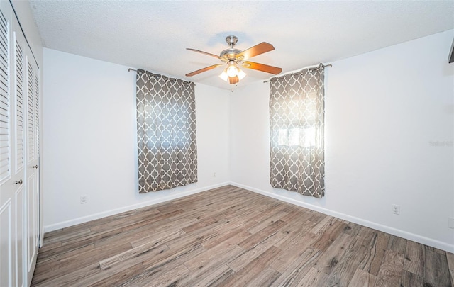 empty room with ceiling fan, a textured ceiling, and light hardwood / wood-style floors