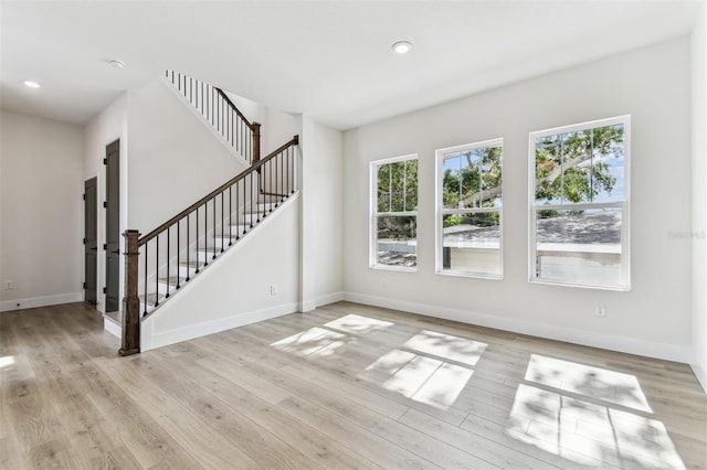 441 42nd Ave NE, Saint Petersburg, FL 33703 - unfurnished living room featuring stairway, light wood-style floors, and recessed lighting