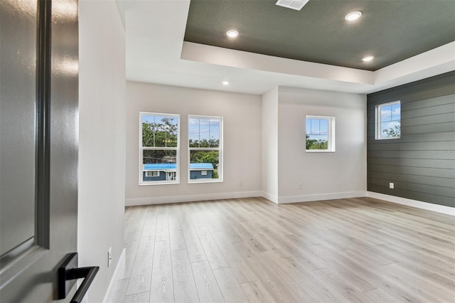 441 42nd Ave NE, Saint Petersburg, FL 33703 - unfurnished living room with light wood finished floors, a raised ceiling, and recessed lighting