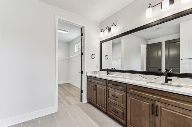 441 42nd Ave NE, Saint Petersburg, FL 33703 - full bath with double vanity, a spacious closet, and tile patterned floors