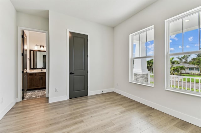 441 42nd Ave NE, Saint Petersburg, FL 33703 - unfurnished bedroom featuring light wood-type flooring and ensuite bath
