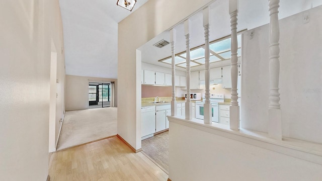 corridor with sink and light hardwood / wood-style floors