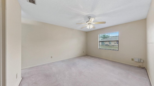 carpeted spare room with a textured ceiling and ceiling fan