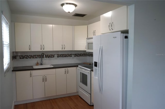 kitchen with sink, dark hardwood / wood-style floors, white cabinets, white appliances, and backsplash