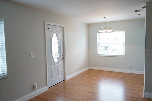 foyer entrance featuring a chandelier and light hardwood / wood-style flooring