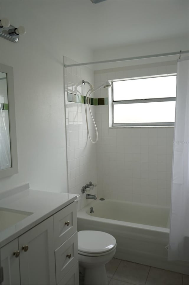 full bathroom featuring vanity, tiled shower / bath, tile patterned floors, and toilet