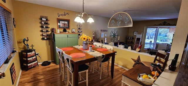 dining area featuring an inviting chandelier and hardwood / wood-style flooring