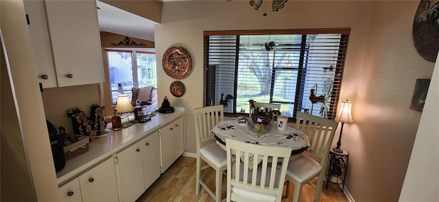 kitchen with kitchen peninsula, white cabinets, and light hardwood / wood-style flooring