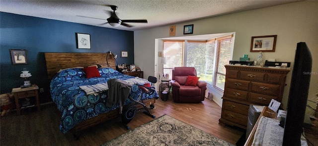 bedroom with wood-type flooring, ceiling fan, and a textured ceiling