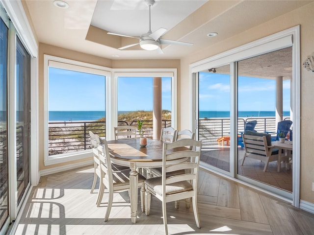 sunroom with a water view, plenty of natural light, and ceiling fan