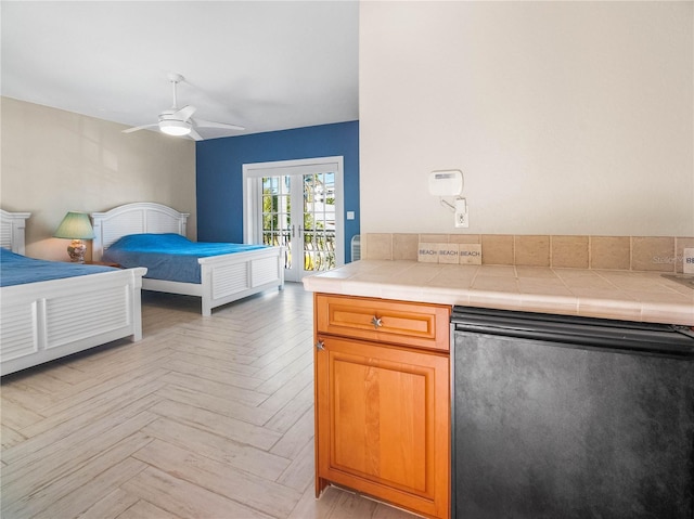 bedroom featuring ceiling fan, light parquet flooring, stainless steel fridge, and access to outside