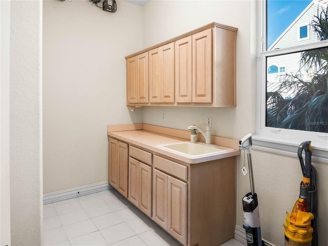 kitchen with light tile patterned floors, sink, and light brown cabinets