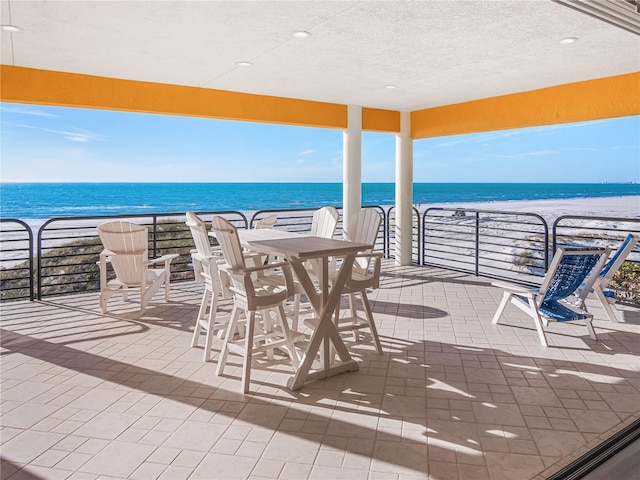 view of patio featuring a beach view and a water view