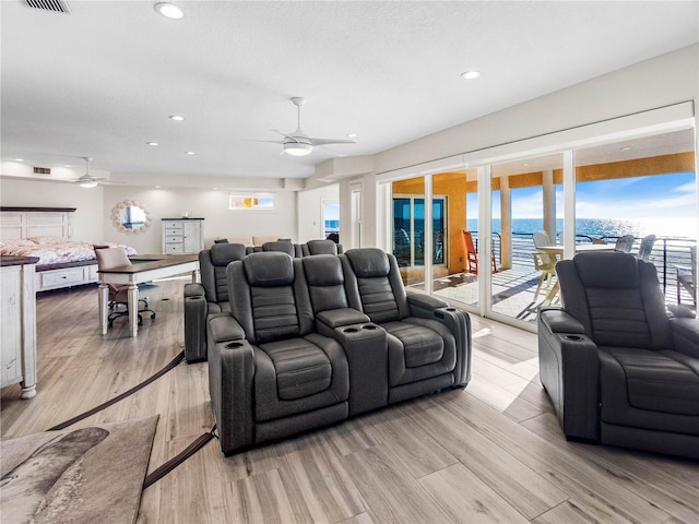 home theater featuring ceiling fan and light wood-type flooring