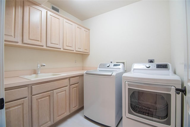 laundry room featuring cabinets, washer and clothes dryer, and sink