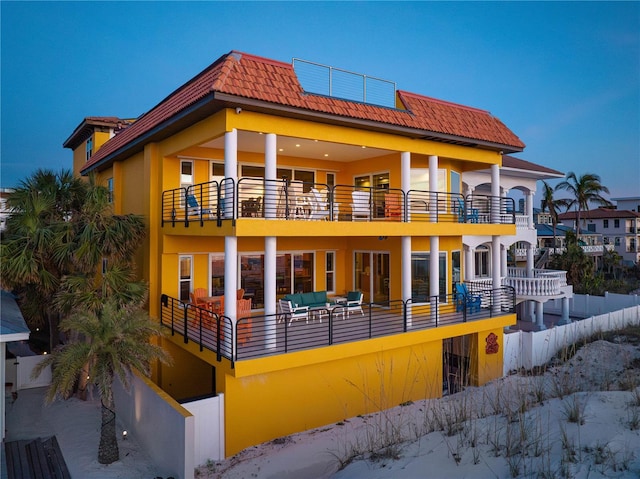 back of property with a balcony and an outdoor hangout area