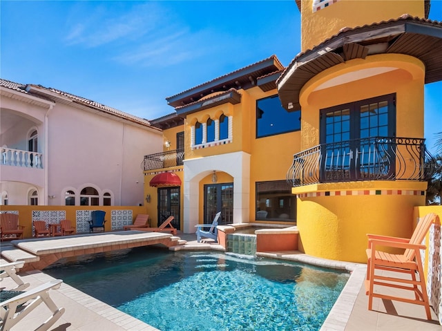 view of swimming pool featuring a patio, french doors, pool water feature, and an in ground hot tub