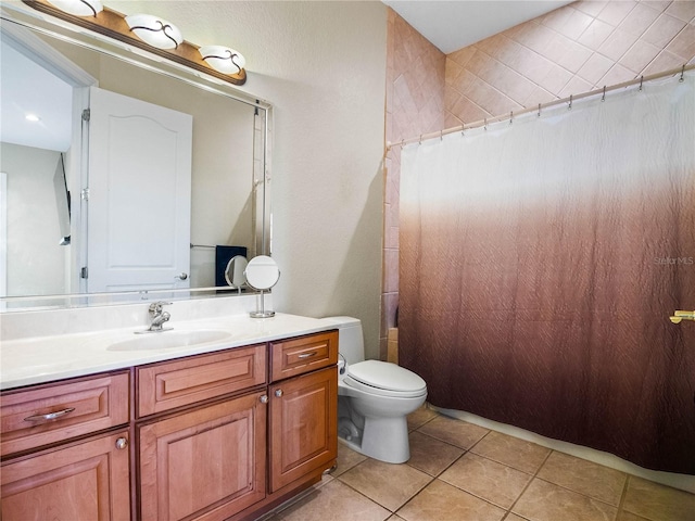 bathroom featuring vanity, tile patterned floors, and toilet