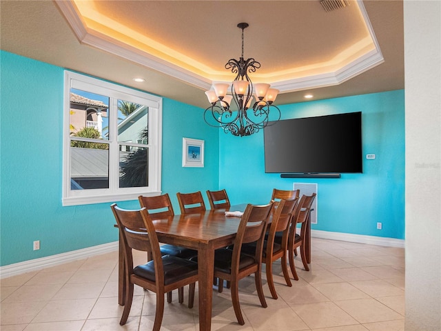 tiled dining room with ornamental molding, a chandelier, and a tray ceiling