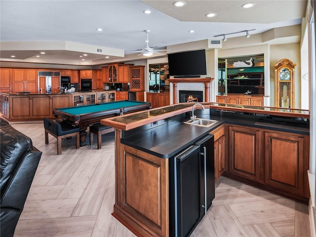 interior space featuring light parquet floors, ceiling fan, sink, and a textured ceiling