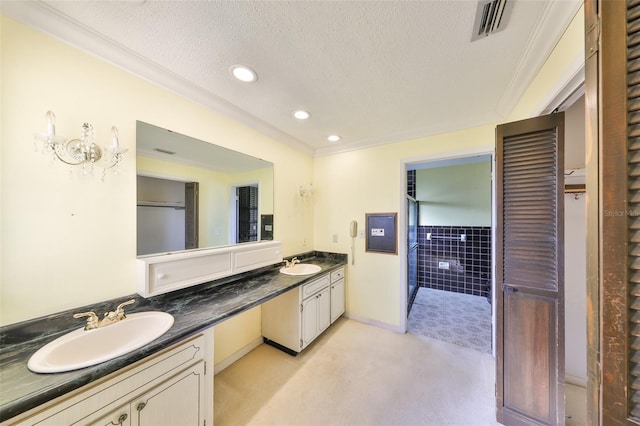 bathroom with crown molding, vanity, and a textured ceiling