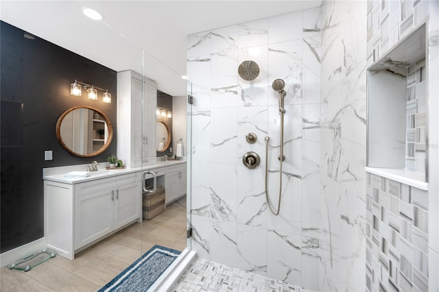 bathroom featuring tiled shower and vanity