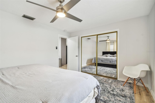 bedroom featuring ceiling fan, a closet, and light wood-type flooring