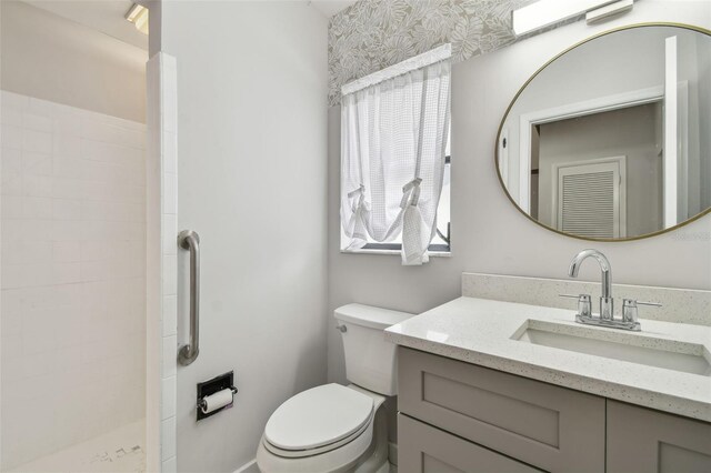 bathroom with vanity, a wealth of natural light, toilet, and walk in shower