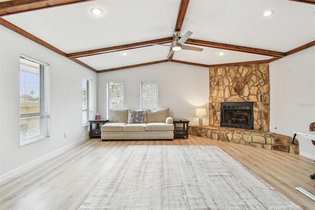 unfurnished living room with vaulted ceiling with beams, light hardwood / wood-style flooring, a fireplace, and ceiling fan