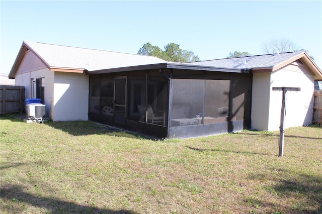 back of property featuring a sunroom, cooling unit, and a lawn