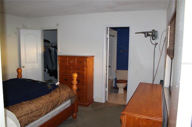 bedroom featuring ensuite bathroom, a spacious closet, a textured ceiling, and a closet