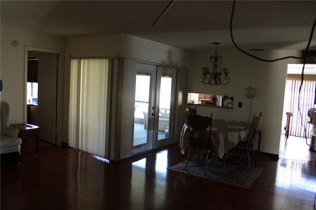 dining area featuring hardwood / wood-style floors, a chandelier, and french doors