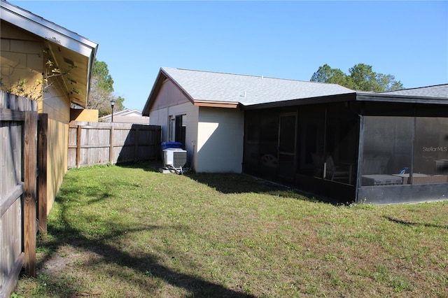 view of yard featuring a sunroom and central AC unit